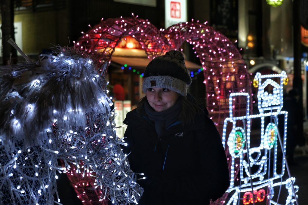 Claire devant un cheval lumineux au festival de la neige de Sapporo