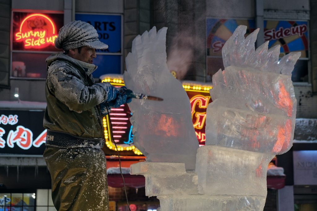 Un sculpteur travaille un gros bloc de glace au festival de la neige de Sapporo