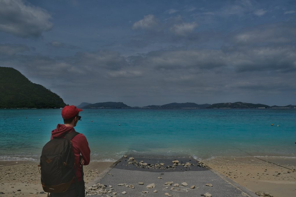 Vincent contemple l'eau bleue de la plage de Tokashiku
