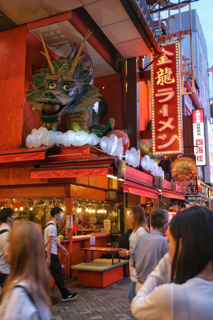 L'enseigne d'un stand de ramen avec un dragon géant sur Dotonbori à Osaka