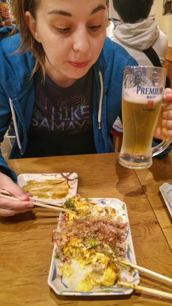 Claire déguste sa bière et une espèce d'okonomiyaki dans un restaurant de Namba