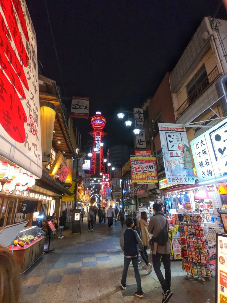 La rue principale de restaurants dans le quartier du Shinsekai et ses enseignes lumineuses