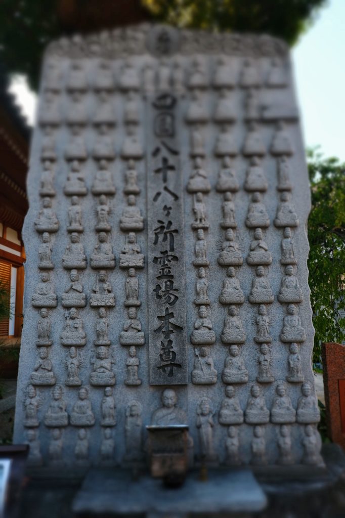 Des personnages sculptés dans un bloc de pierre au temple Horaku-ji