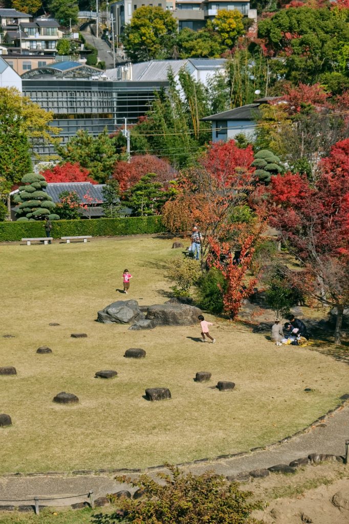 Des enfants jouent dans le jardin du château d'Ikeda à côté des arbres d'automne