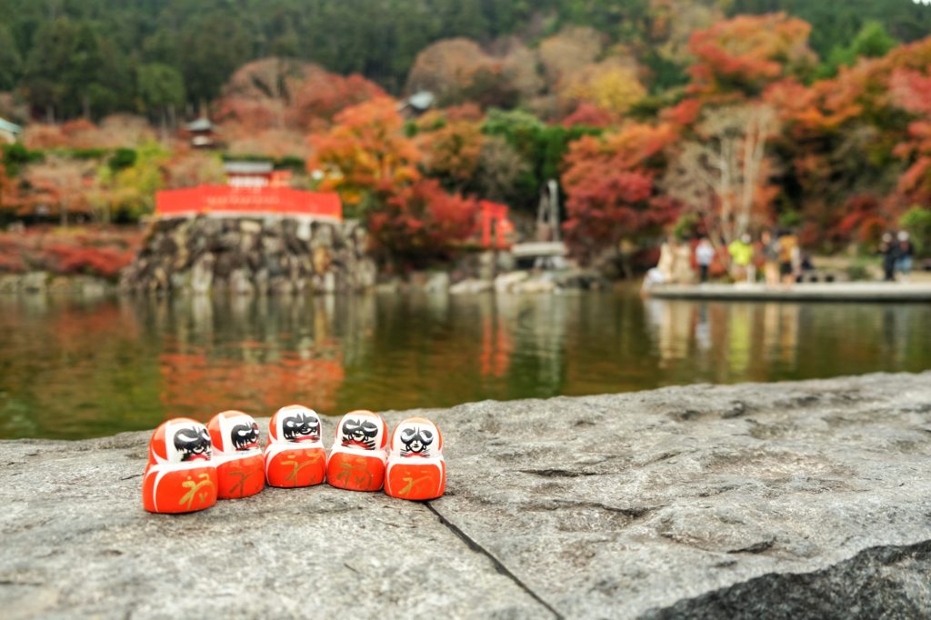 Des daruma devant l'étang du temple Katsuo-ji à Minoo