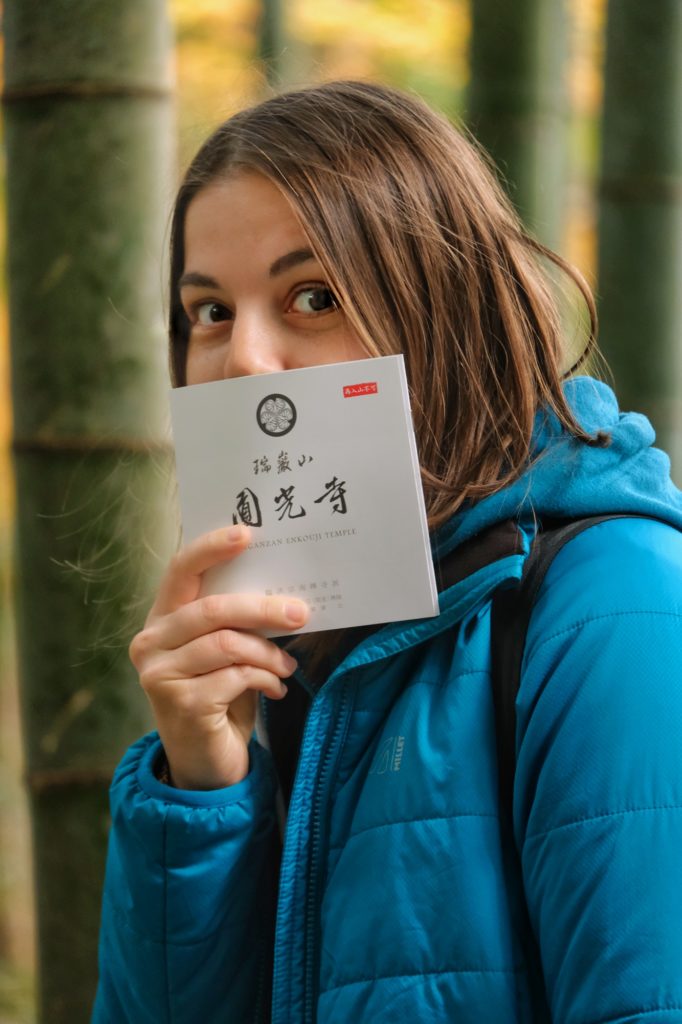 Claire se cache derrière le prospectus du temple Enko-ji