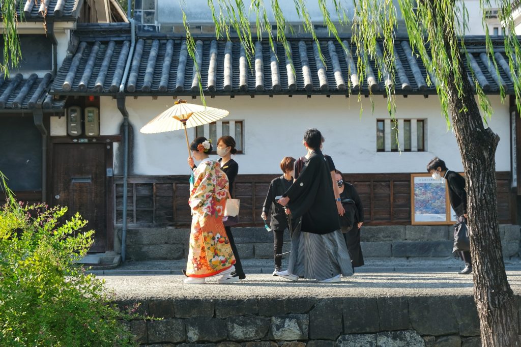 Des mariés en habits traditionnels le long du canal du quartier Bikan de Kurashiki