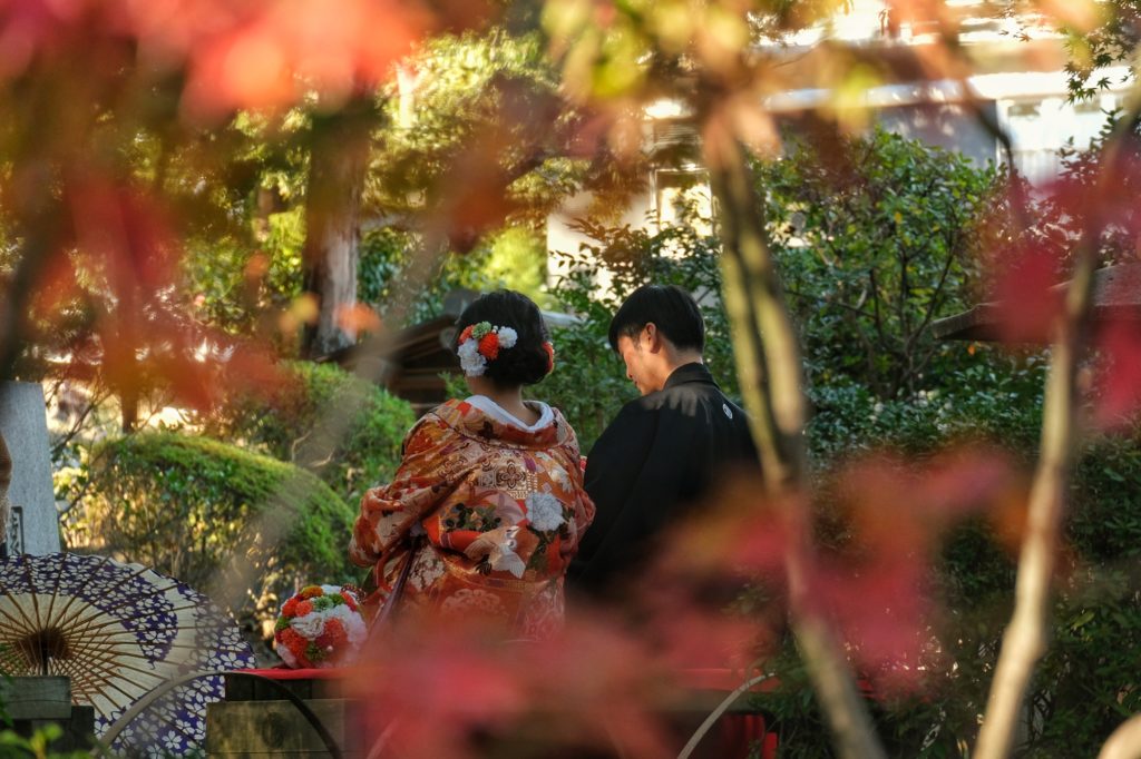 Un couple de mariés en habits traditionnels japonais dans le parc Nishinomaru Teien du château de Wakayama