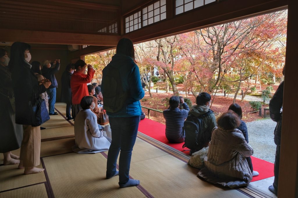 Claire et les visiteurs du temple Enko-ji dans son pavillon profitent des momiji